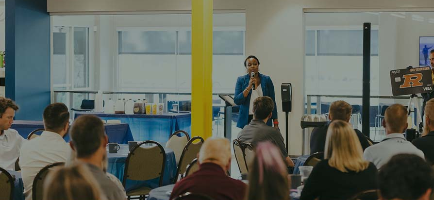 Dr. Gbemisola Adetayo speaking into a microphone in front of a seated audience